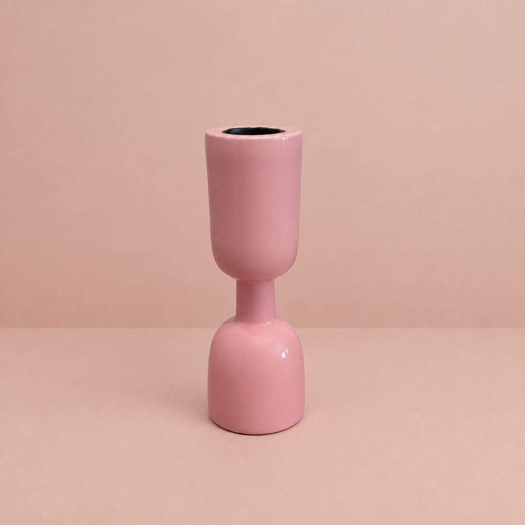 Pink enamel taper holder on a warm blush background