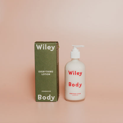 Wiley Body lotion bottle and packaging on a pink background