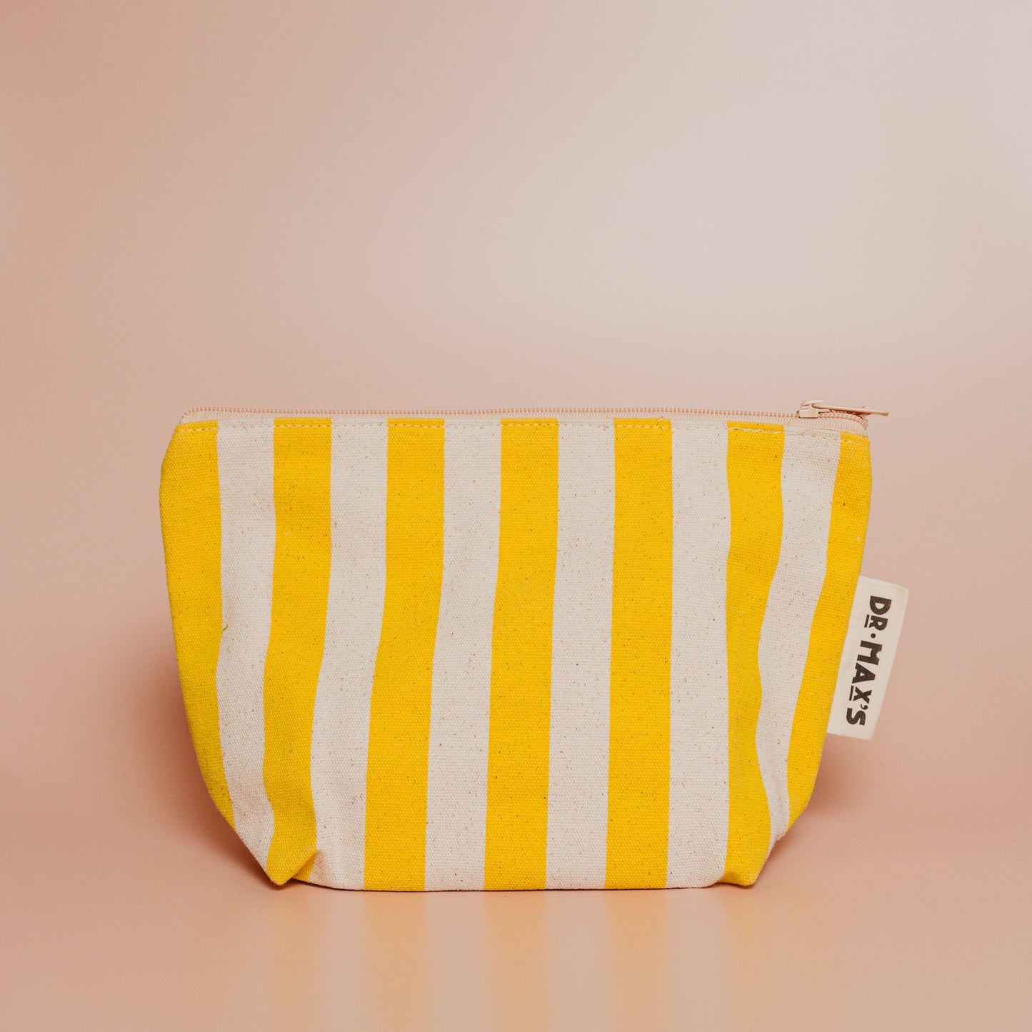 Yellow and white striped pouch with a brand tag on a beige background