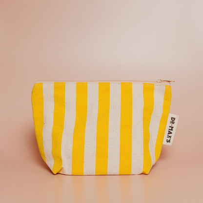 Yellow and white striped pouch with a brand tag on a beige background