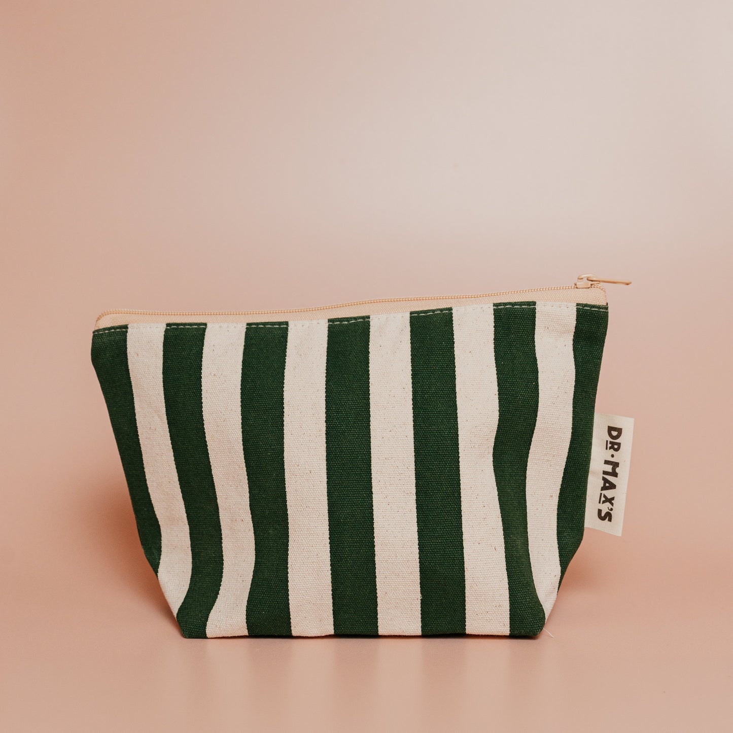 Green and white striped pouch with a brand label on a pink background