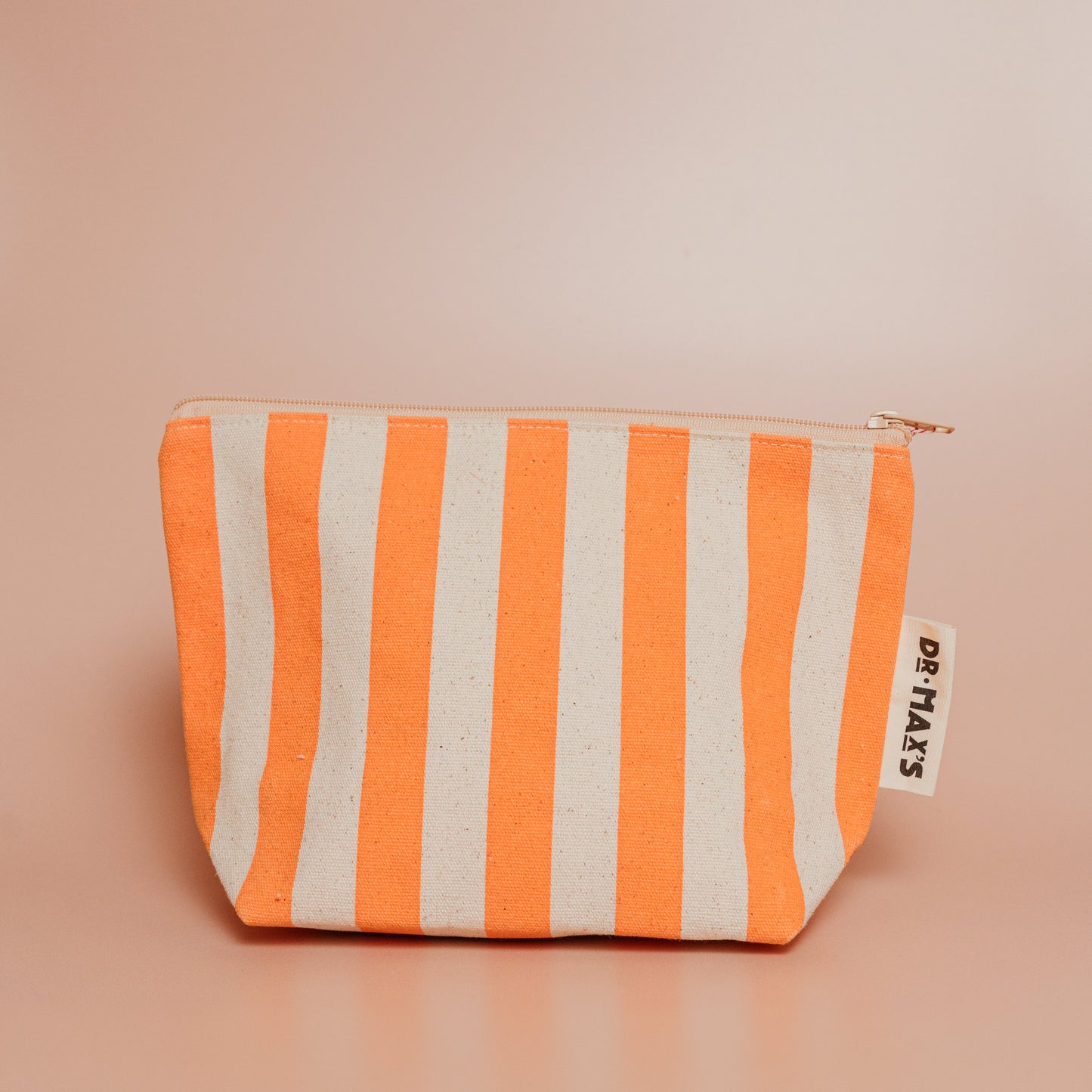 Striped pouch with orange and beige pattern on a beige background