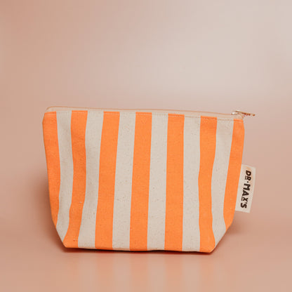 Striped pouch with orange and beige pattern on a beige background