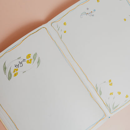 Floral embroidered tablecloth with yellow flowers and green leaves on a beige background