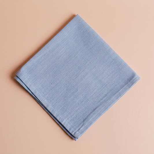 Blue napkin with the standard blush-peach background