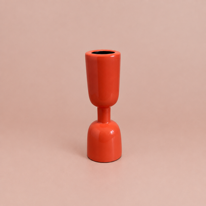 Coral enamel taper holder on a warm blush background