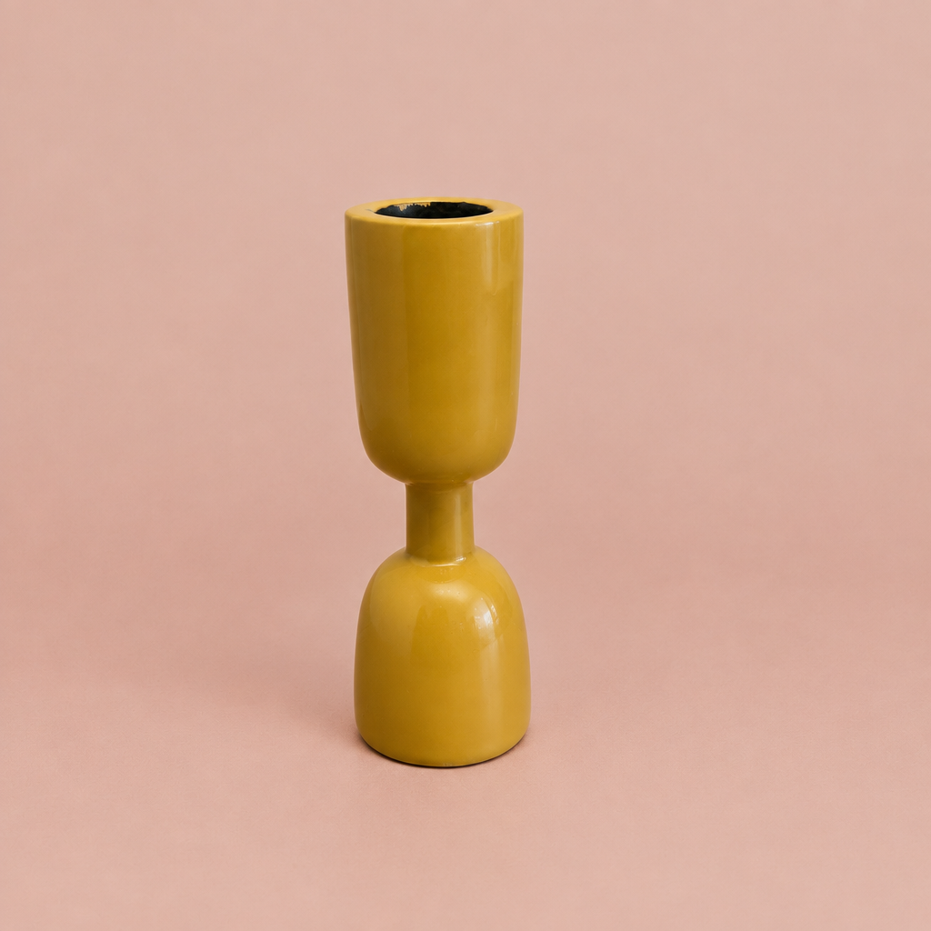 Yellow enamel taper holder on a warm blush background