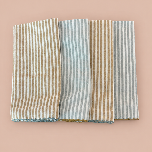 Four striped cotton napkins on a blush background
